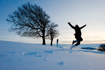 endlich Winter -- Frau springt begeistert in die Luft