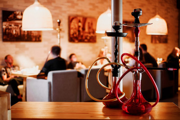 Fototapeta na wymiar group of red hookahs shisha on table in interior