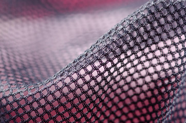 Black mesh lining fabric textile material cloth macro on blur background