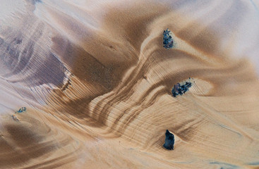 Natürliches Muster von Wellenlinien auf dem Sand nach Ebbe. © Belozorova Elena