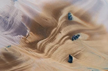 Natürliches Muster von Wellenlinien auf dem Sand nach Ebbe. © Belozorova Elena