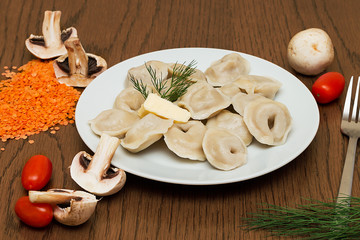 Dumplings on a plate on a brown background.