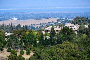 Fototapeta na wymiar Mansions on the hills surrounding San Francisco bay area; the bay shoreline visible in the background