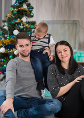 Happy family of three with little boy o  Christmas with decorations