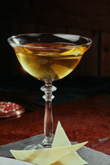 Yellow cocktail based on white wine in a beautiful goblet glass served with parmesan cheese on a copper background. close-up. Series of photo.