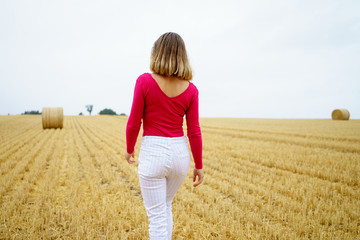 Naklejka na ściany i meble girl walking in a harvested field