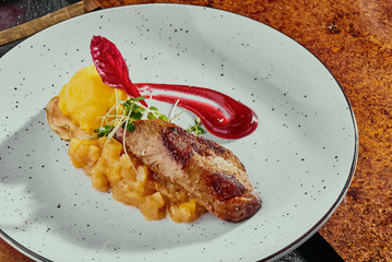 foie gras with citrus chutney and mango sorbet on a white plate on a copper background. close up. © Kirill