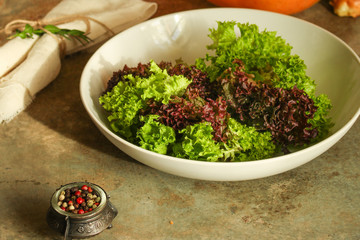 fresh lettuce leaves  salad in a white plate on a wooden table background. top view. copy space