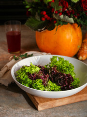 fresh lettuce leaves  salad in a white plate on a wooden table background. top view. copy space