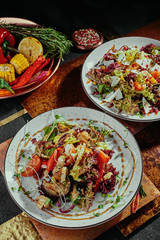 Salad with pomegranate, corn, tomatoes, arugula, parmesan cheese and cranberries and grilled vegetables salad on a white plates on a copper background. flat lay.  Close-up