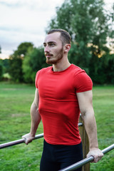 Young man doing exercises on the horizontal bars