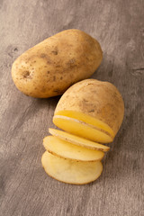 Raw sliced potato over wood background