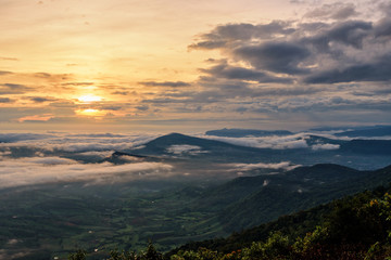 Beautiful nature landscape the sun is above the sea fog that covers the mountains and bright sky during sunrise in the winter at viewpoint of Phu Ruea National Park, Loei province, Thailand.