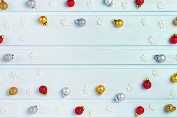 Empty place for text and inscription, copy space. Small Christmas balls, red and silver balls are randomly laid out in a circle. White decorative snowflakes. Festive layout.
