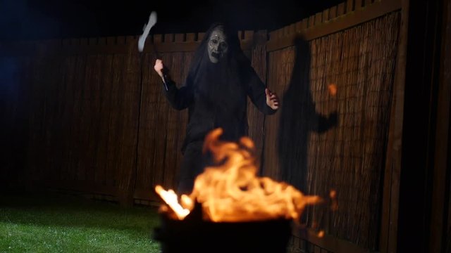 Scary Cult Leader In A Mask Dances In Front On A Fire