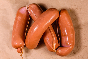 Heap of sausages on a brown wrapping paper. Top view