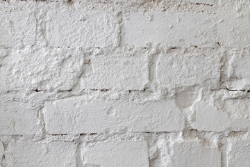 White brick wall. An old brick wall painted with paint and supplemented with plaster. Light background.
