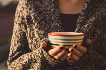 Woman holding a ceramic cup in both hand