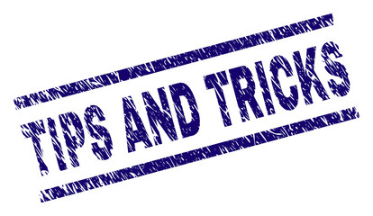 TIPS AND TRICKS seal print with scratced style. Blue vector rubber print of TIPS AND TRICKS caption with unclean texture. Text caption is placed between parallel lines.