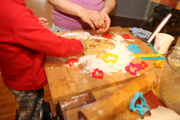 mother and her little son make shortbread dough cookies at home in the kitchen
