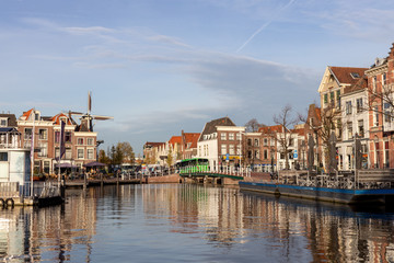 Fototapeta na wymiar Medieval picturesque city of Leiden in the Netherlands with old historic cityscape on a sunny afternoon with a Windmill in the background