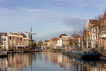 Fototapeta premium Picturesque medieval city of Leiden in the Netherlands with old historic cityscape on a sunny afternoon with a Windmill in the background