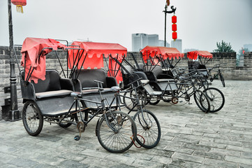 Fototapeta na wymiar Rent rickshaws tricycles on city wall in Xi'an, China