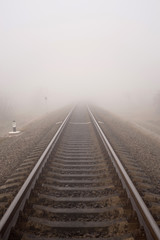 Fototapeta na wymiar Foggy railway landscape. Vertical photo.