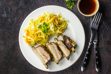 Smoked Roasted pork ribs on plate with cole slaw. Traditional american BBQ food.