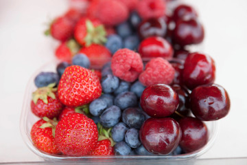 Fresh , raspberries, strawberries, cherries, blueberries in the box on the market