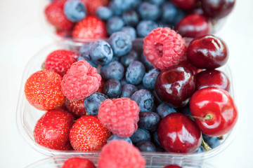 Fresh , raspberries, strawberries, cherries, blueberries in the box on the market