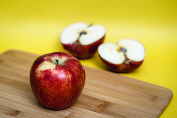 Red apple next to slices of another apple.