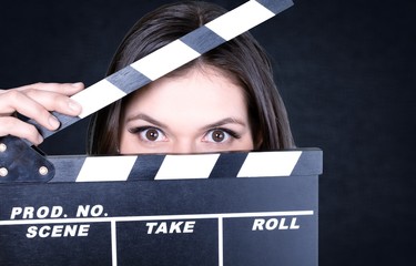 Young woman with movie clapper isolated on white