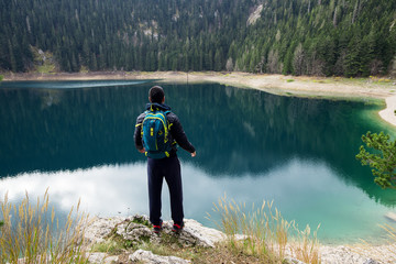 Traveler man enjoying mountains and lake landscape