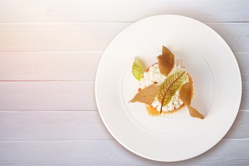 Delicious cupcake with leaves on white plate
