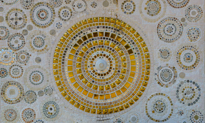 Close up handwork on fancy white and gold ceramic decorated the wall of buddhism pagoda