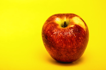 big red apple with yellow background, isolated.