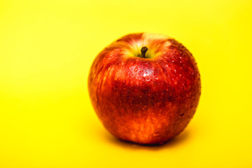 big red apple with yellow background, isolated.