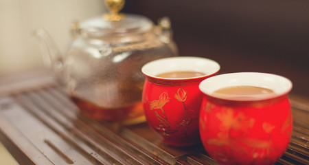 Chinese tea ceremony, Puer  in assortment, Ceramic glass teapot for brewing with tea bowls on a bamboo table