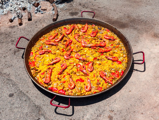 Seafood Paella. The national Spanish dish of paella in a large skillet is cooked on an open fire, at the stake.