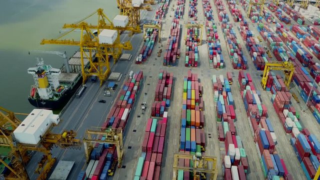 4K. Logistics and transportation of container cargo freight ship with container crane in shipyard. Logistic import export business and transport industry. Aerial view taken from drone.