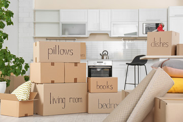 Cardboard boxes and household stuff in kitchen. Moving day