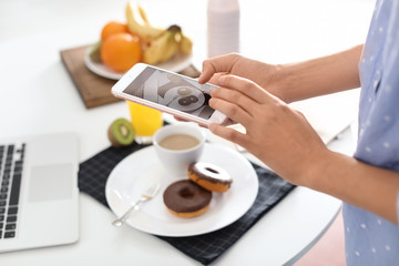 Fototapeta na wymiar Food blogger taking photo of breakfast at home, focus on phone display