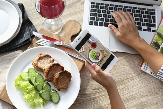 Blogger taking photo of food with mobile phone, closeup