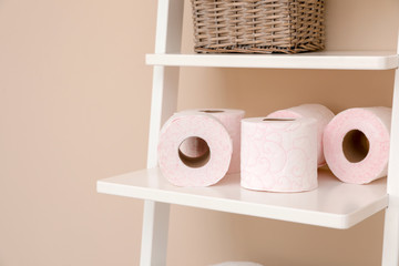 Toilet paper rolls on shelving unit in bathroom