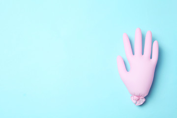 Inflated medical glove on color background, top view. Space for text
