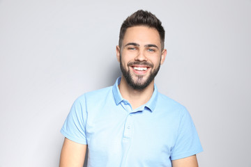 Portrait of handsome young man against light background