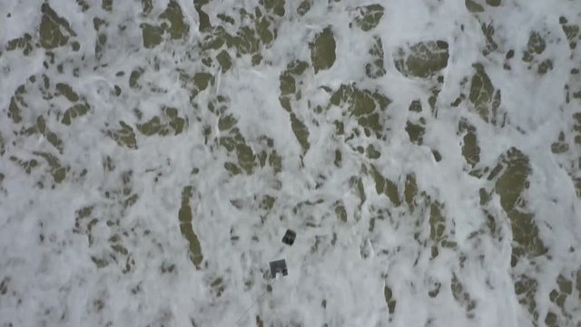 A drone carries a fishing line and a bait to go fishing.