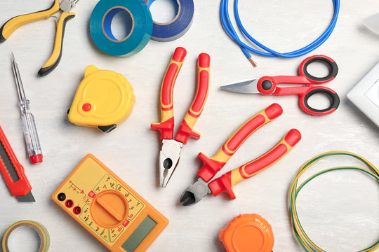 Set of electrician's tools on light background, flat lay