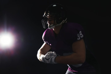 American football player wearing uniform on dark background. Space for text